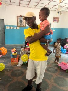 Fr Kingsley Ihejirika holding a DMIWOO sponsored orphan child in Obike. 2024